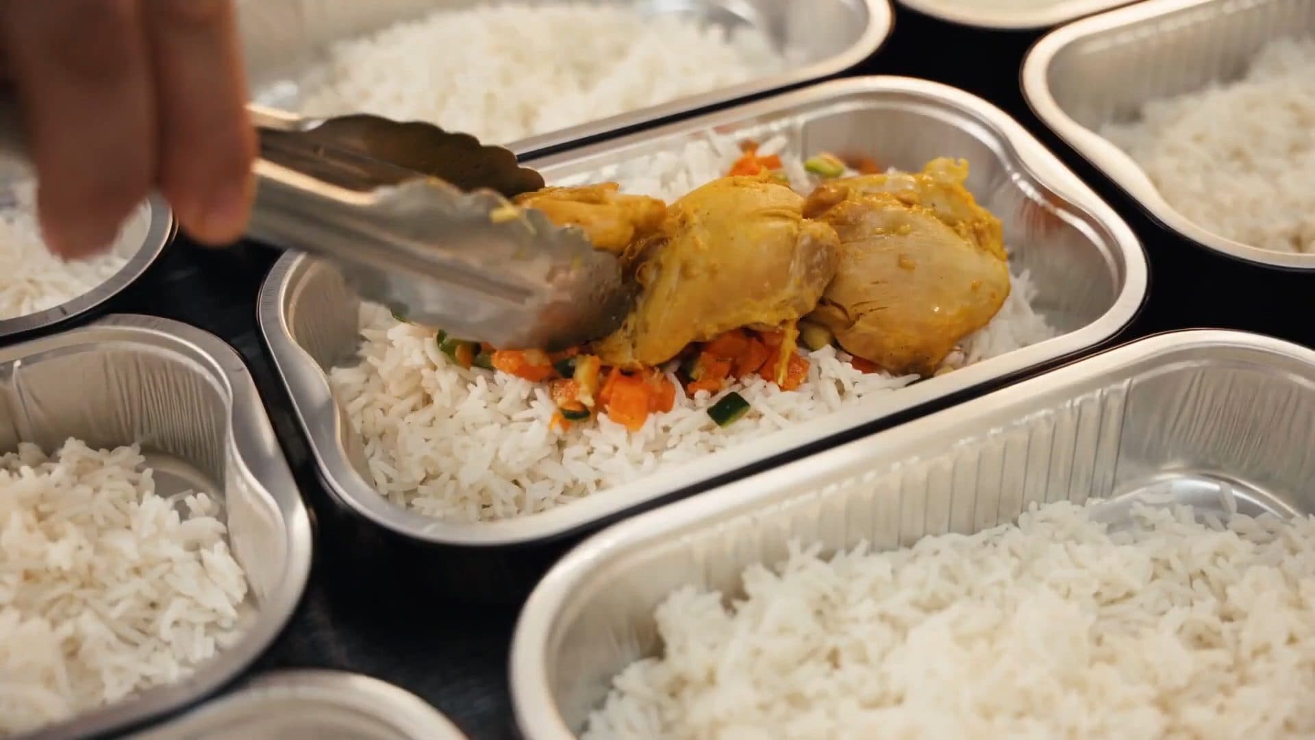 En cuisine chez Traiteur Maxime : du poulet au curry dressé à la pince dans les barquettes