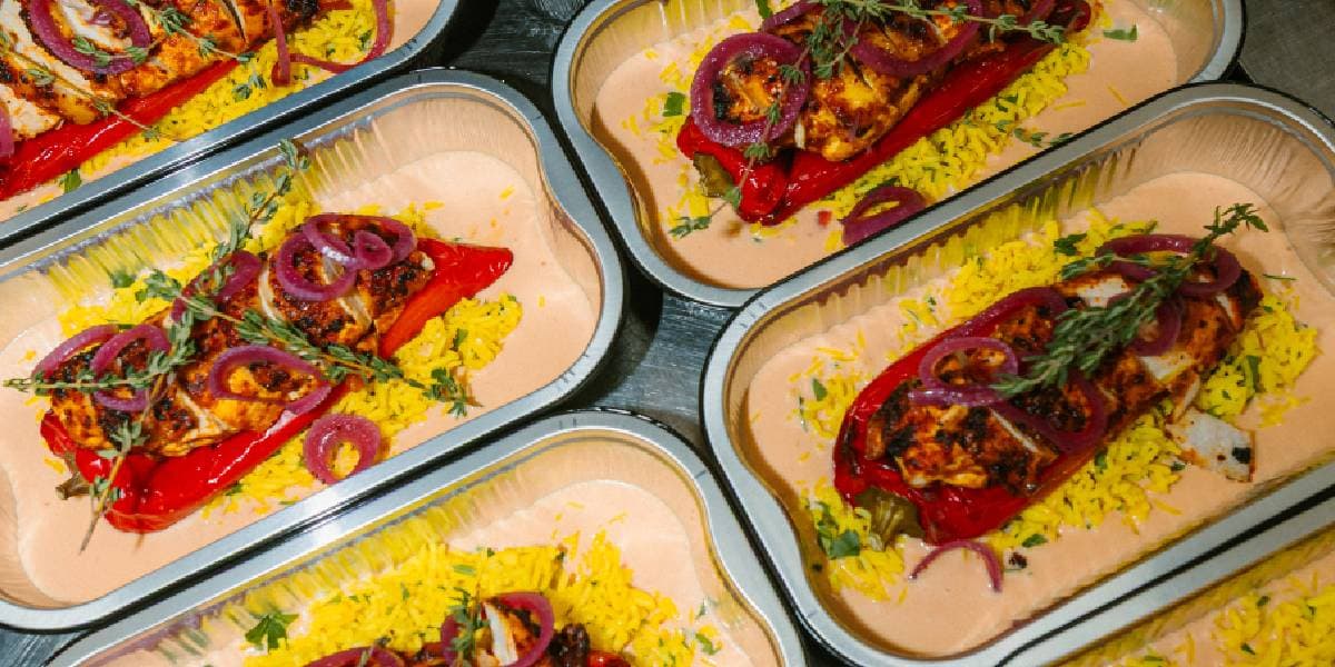 Barquettes de poulet grillé, poivron rouge et riz jaune, prêtes à être scellées